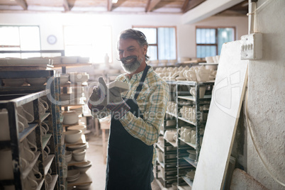 Male potter holding craft product