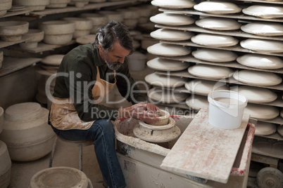 Male potter molding a clay