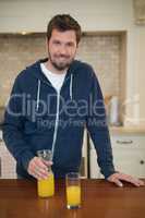 Man holding glass of juice in the kitchen
