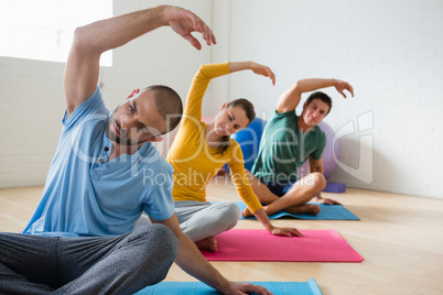 Yoga instructor with students exercising at club