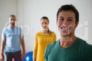 Portrait of man with yoga instructor and woman in club