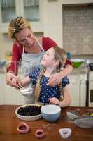 Mother and daughter preparing blue berry pie
