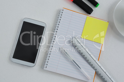 Mobile phone and stationery on white background