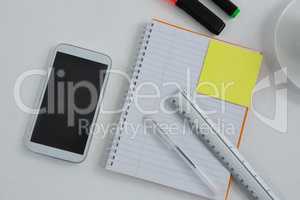 Mobile phone and stationery on white background