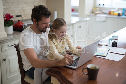 Father and daughter working on laptop