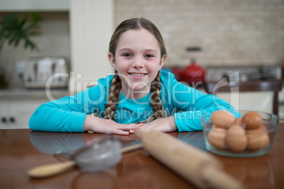 Girl sitting on table in the kitchen