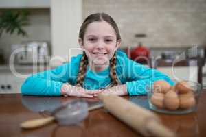 Girl sitting on table in the kitchen