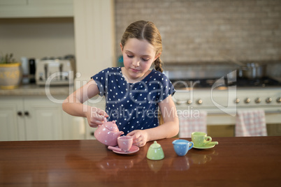 Young girl pouring tea in the cups