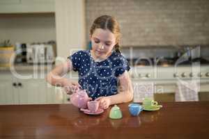 Young girl pouring tea in the cups