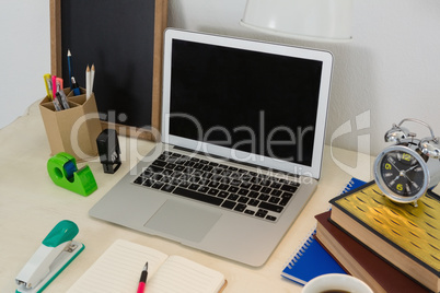 Laptop and various office accessories on table