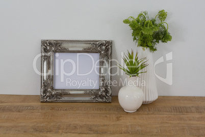 Picture frame and vase on table
