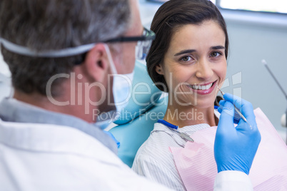 Woman smiling while receiving dental treatment at clinic