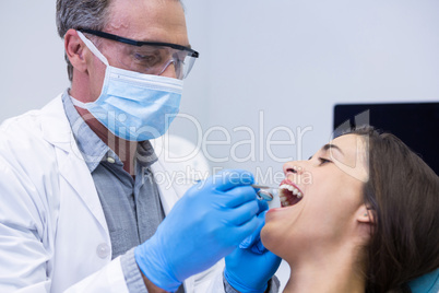 Dentist examining woman at clinic