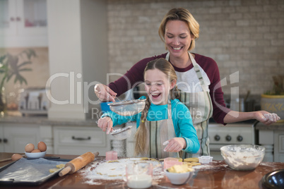 Mother and daughter preparing cookies in kitchen