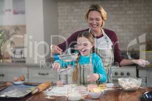 Mother and daughter preparing cookies in kitchen