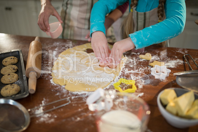 Mother and daughter preparing cookies in kitchen