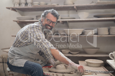 Portrait of male potter molding clay