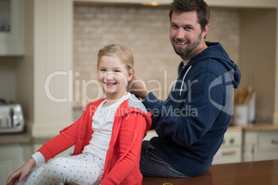 Father making daughters hairstyle at home