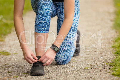 Woman tying shoe laces in the park