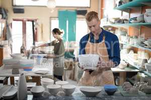 Male potter checking ceramic bowl