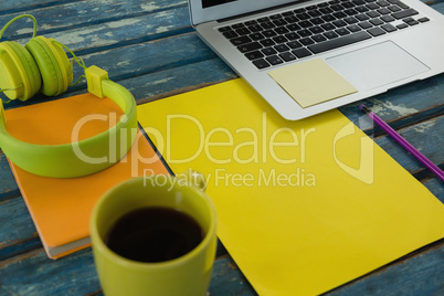 Black coffee and office accessories on wooden plank