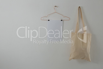 Paper and bag hanging against white wall