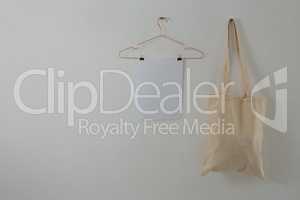 Paper and bag hanging against white wall
