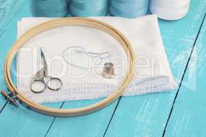 wooden round embroidery frame and white fabric for cross stitchi