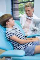 Dentist talking with boy at medical clinic
