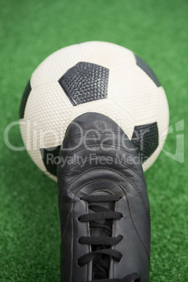 Football and cleats on artificial grass