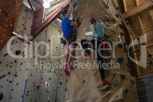 Low angle view of athletes rock climbing in studio