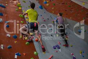 Athletes rock climbing in fitness studio