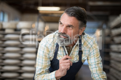 Thoughtful male potter in pottery workshop