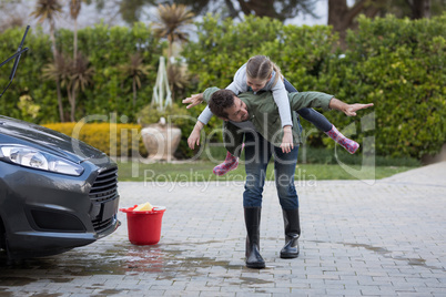 Teenage girl and father washing a car