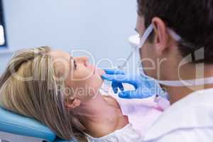 Close up of dentist examining woman