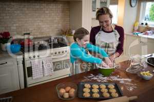 Mother and daughter preparing cookies in kitchen