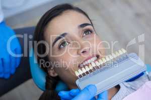Dentist holding medical equipment while examining woman