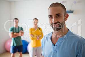 Portrait of yoga instructor with student in health club