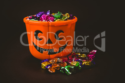 Bucket with colorful wrapped chocolates during Halloween