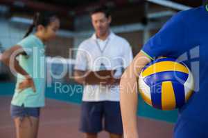Volleyball player holding ball in court