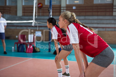 Female players playing volleyball in the court