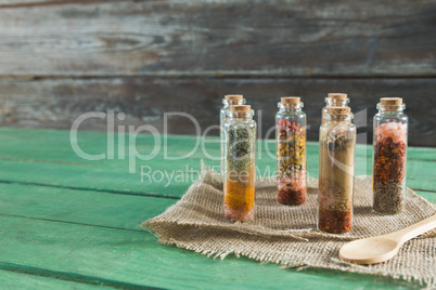 Various spices in bottles on wooden table