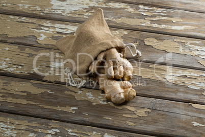 High angle view of burlap and fresh gingers on weathered table