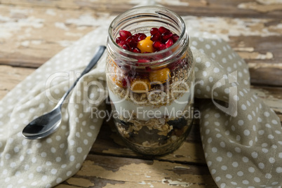 Yogurt with pomegranates and golden berries in glass jar