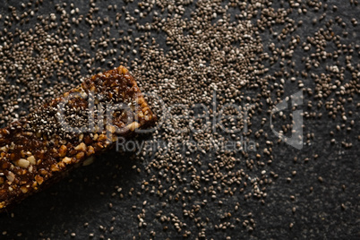 Granola bar with grains on black background