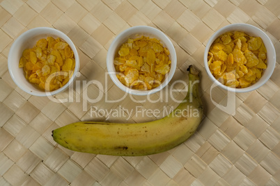 Three bowls with breakfast cereals and banana