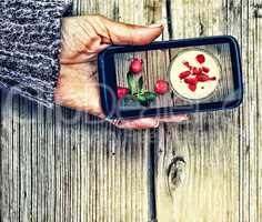 Smartphone in a female hand. display image of strawberry milkshake Healthy Eating