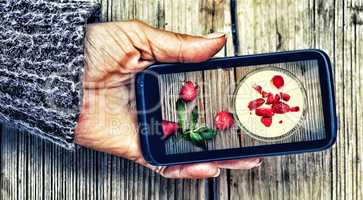 Smartphone in a female hand. display image of strawberry milkshake Healthy Eating