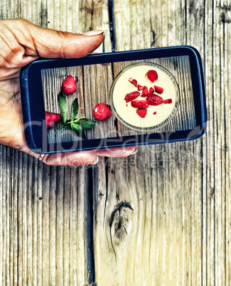 Smartphone in a female hand. display image of strawberry milkshake Healthy Eating