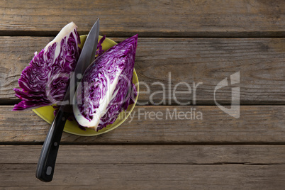 Sliced red cabbage in plate on wooden table
